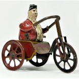 A tinplate toy, depicting a gentleman riding a tricycle, hand painted figure, 14cm tall