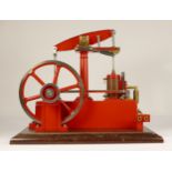 A Stuart Turner stationery beam engine comprising of red body with vertical single cylinder engine
