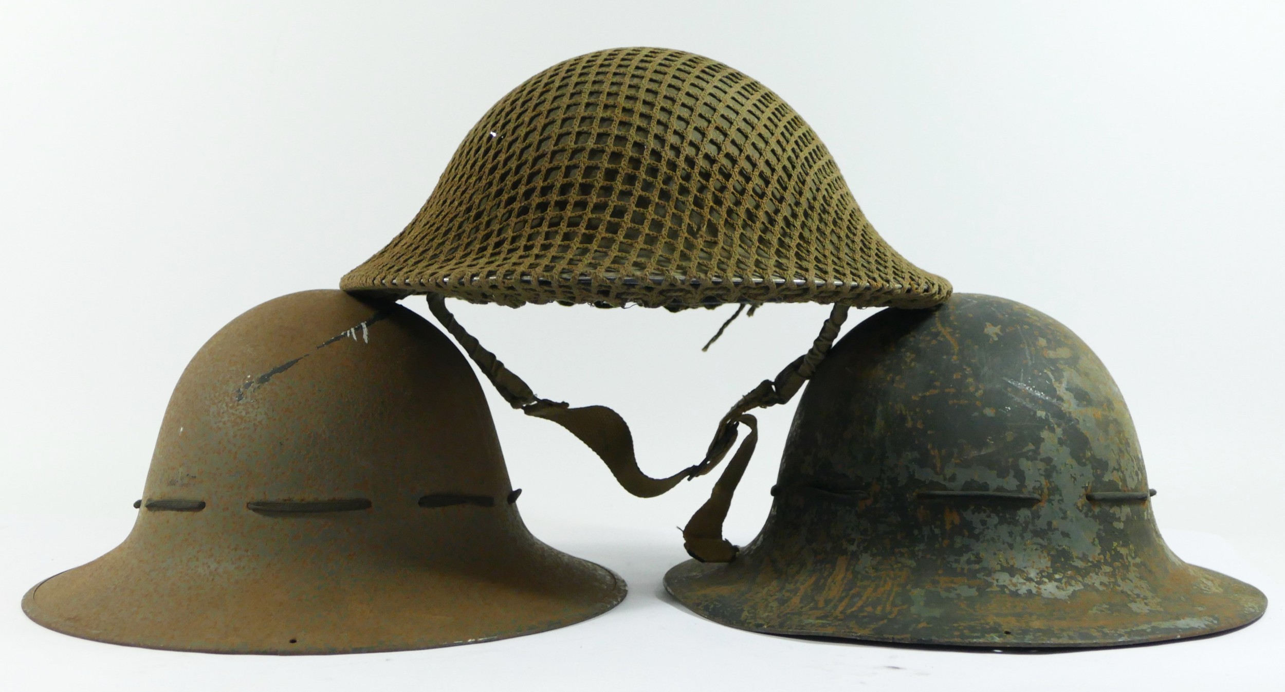 A WWII British Army Brodie helmet, dated 1941 and two WWII Zuckerman helmets, one dated 1941 (3).