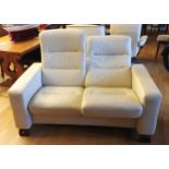 A Stressless two seater reclining sofa, upholstered in cream leather - W: 142 D: 74 H: 100cm.