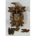 A mid 20th century Black Forest cuckoo clock, having three weights with musical carousel.