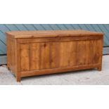 A modern stained pine blanket box, hinged lid and paneled sides - W: 108 H: 47 D: 51cm.