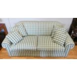 A modern three seater metal framed sofabed upholstered in a green and white cotton checked