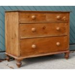 An early 20th Century stripped pine 2+2 height chest of drawers having bun handles raised on