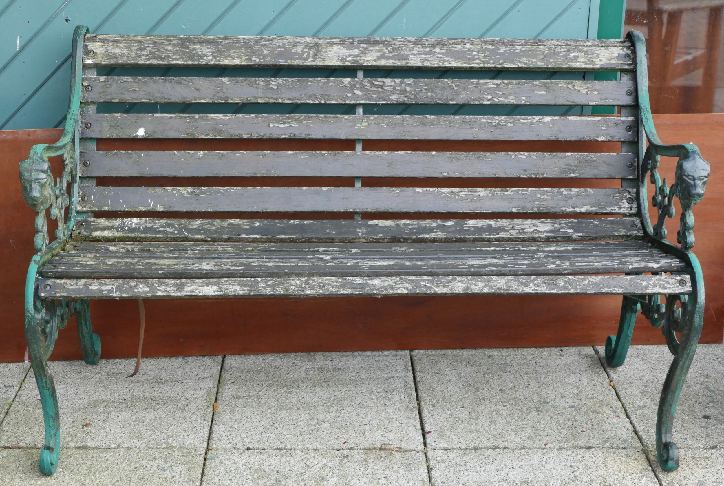 A garden bench having hardwood slats and heavy cast iron ends with scroll legs - 130cm wide together