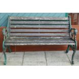 A garden bench having hardwood slats and heavy cast iron ends with scroll legs - 130cm wide together