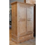 A modern rustic pine single wardrobe, twin doors with single long drawer below raised on a