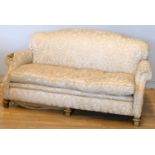 An early 20th century mahogany framed three seat sofa, with shaped back, sweep back and scroll arms,