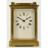 A brass cased 8 day carriage clock, enameled dial with Roman numerals - 12cm tall.