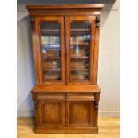 A Victorian mahogany bookcase, having moulded cornice supported by two decorative carved corbels,