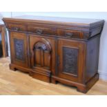 A gothic inspired mahogany sideboard comprising of three drawers above three cupboard doors,