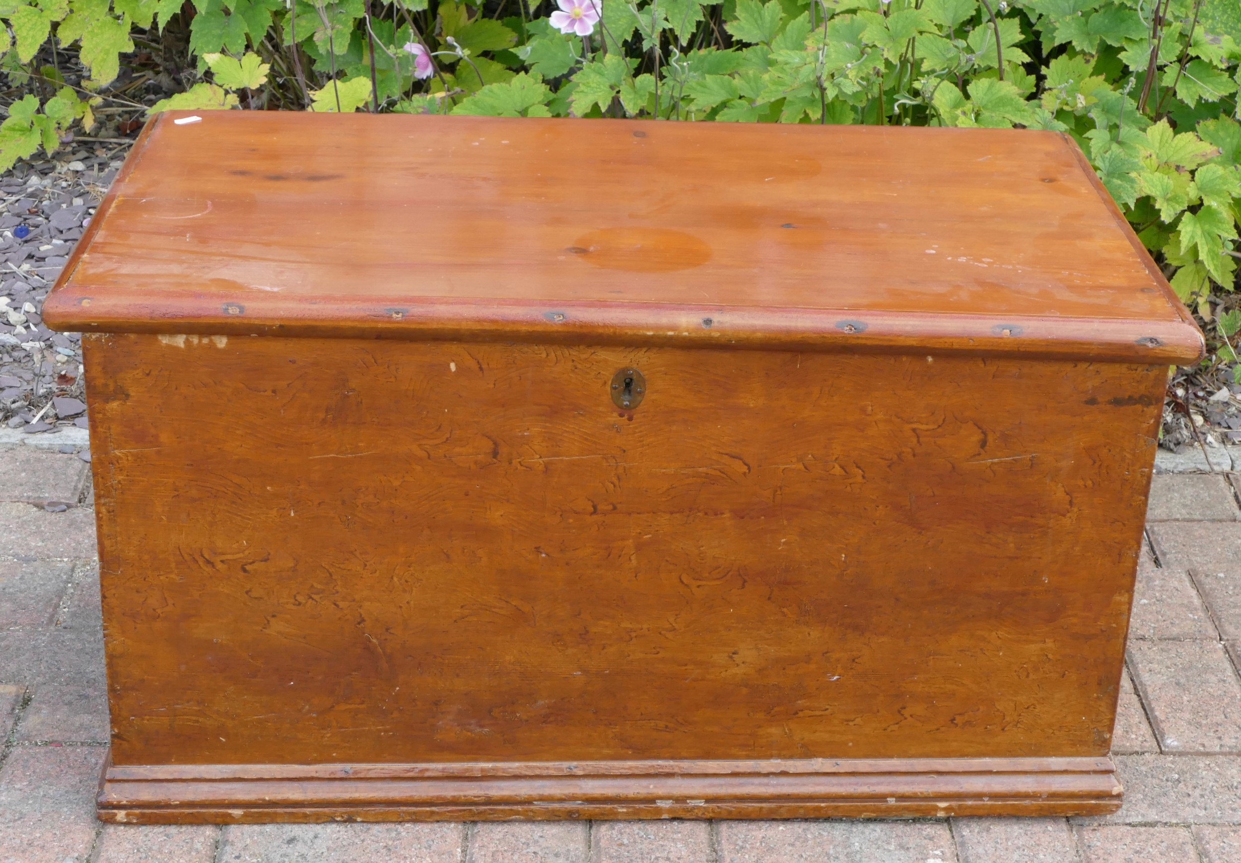 A stained pine Victorian blanket box, interior fitted with candle tray, having original carry