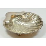 An Edwardian silver shell dish, Birmingham 1907, raised on three ball feet, 14 x13cm, 83gm