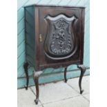 A French Louis XIV style ebonised music cabinet having scalloped edge top above a carved panel door,