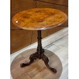A walnut circular top table, with fruitwood inlay, on a pedestal carved wood base, on three feet,