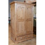 A modern rustic pine single wardrobe, twin doors with single long drawer below raised on a