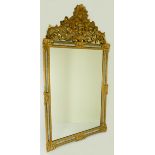 A carved gilt wood ornate over mantle mirror with pierced surmount - 124cm x 67cm.
