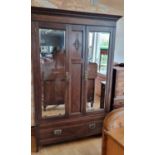 An Edwardian oak two mirror door wardrobe by Bernard H. Rose, Woodseats, cabinet makers, single draw