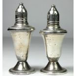 A sterling silver pair of pepper pots, glass liners