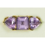 A 9ct gold and amethyst three stone ring, the 8mm square cut stone flanked by triangular stones, N