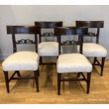 A set of eight mid 19th century mahogany dining chairs, having concave top rail over a carved