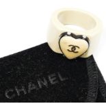 Chanel, a white resin band ring, c.2000's, with applied heart inset with double C's, plague to