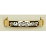 An 18ct gold and diamond seven stone diamond ring, channel set with brilliant cut stones, weight