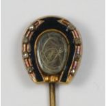 A Victorian gold and enamel mourning horseshoe stickpin, the locket with coarse hair (horse?),