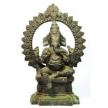 An Indian brass seat Ganesh statue, with hoop behind, 33cm.