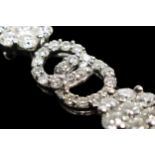 A 14K white gold and diamond line bracelet, claw set with 12 brilliant cut diamond set clusters,