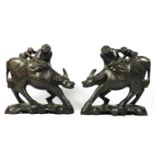 A Chinese pair of carved hardwood and inlaid silver wire water buffalos with two riders, glass eyes,