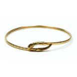 A 9ct gold snake bangle, garnet eyes, diameter 65mm, 5.3gm