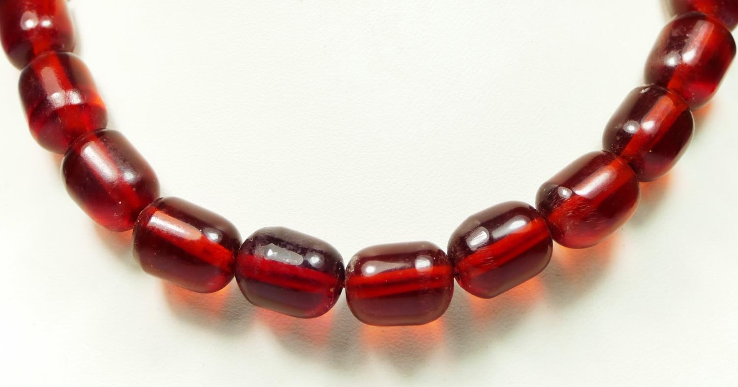 A cherry red amber bead necklace, 63gm, the largest bead 17 x 12mm