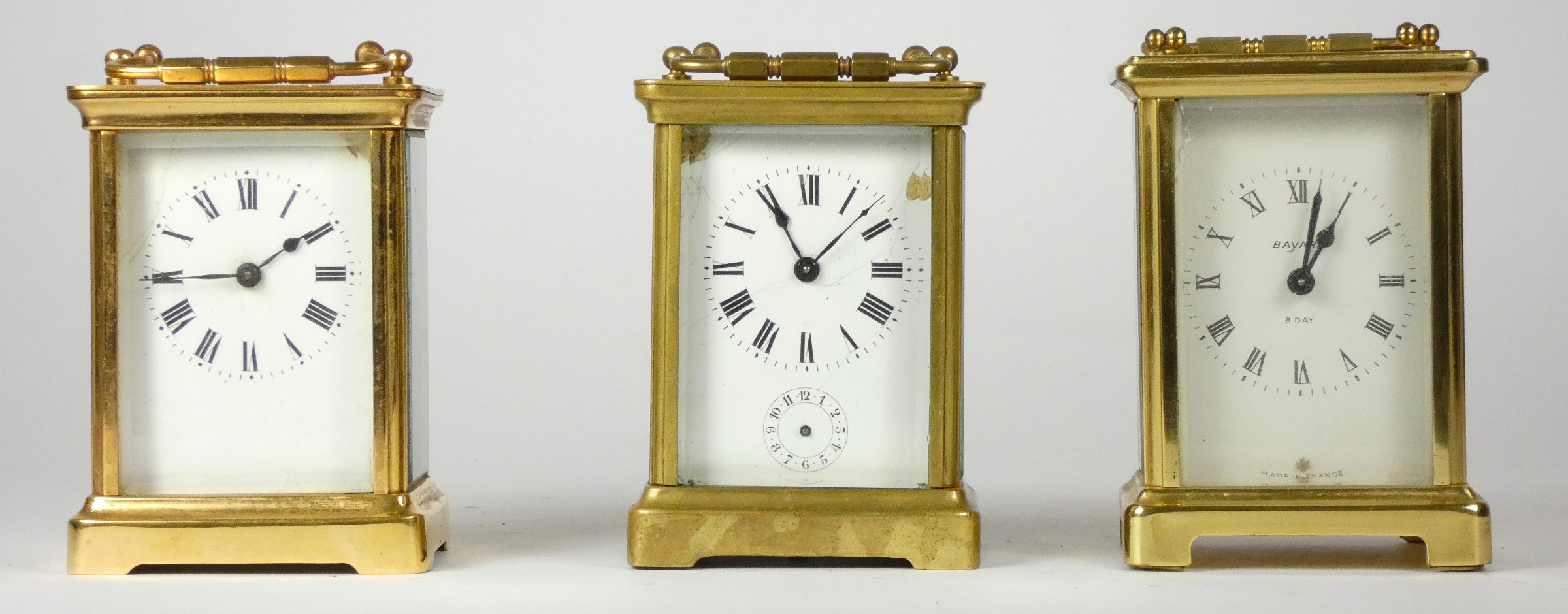 Three early 20th Century brass carriage clocks, white enameled dials with Roman numerals, 8 day