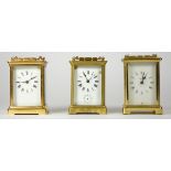 Three early 20th Century brass carriage clocks, white enameled dials with Roman numerals, 8 day