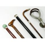 A collection of walking sticks and canes, to include a silver sleeved cane with green agate