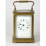 An early 20th Century brass carriage clock, white enamel dial with Roman numerals, the 8 day
