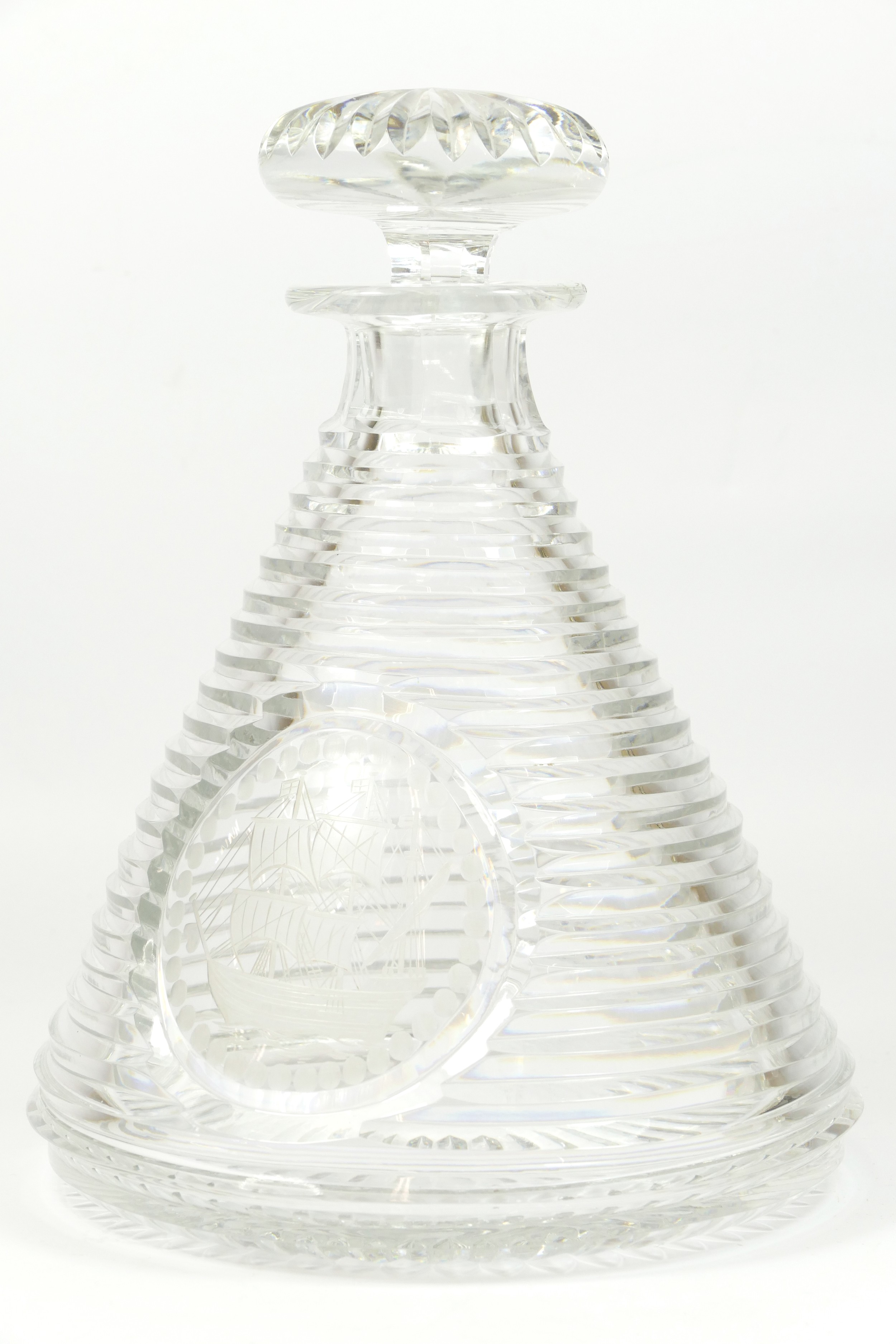 A cut glass ships decanter, with hand engraved image of a schooner, ribbed body, both the stopper