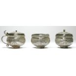 An Indian Raj period silver three piece cruet set, with floral chased and embossed decoration, 160gm
