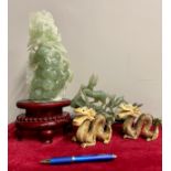 A Chinese green jadeite sculpture, of a pair of exotic birds perched upon vines of grapes, raised on