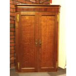 A late 19th century George III style oak wall mounted corner cupboard, panelled door to internal