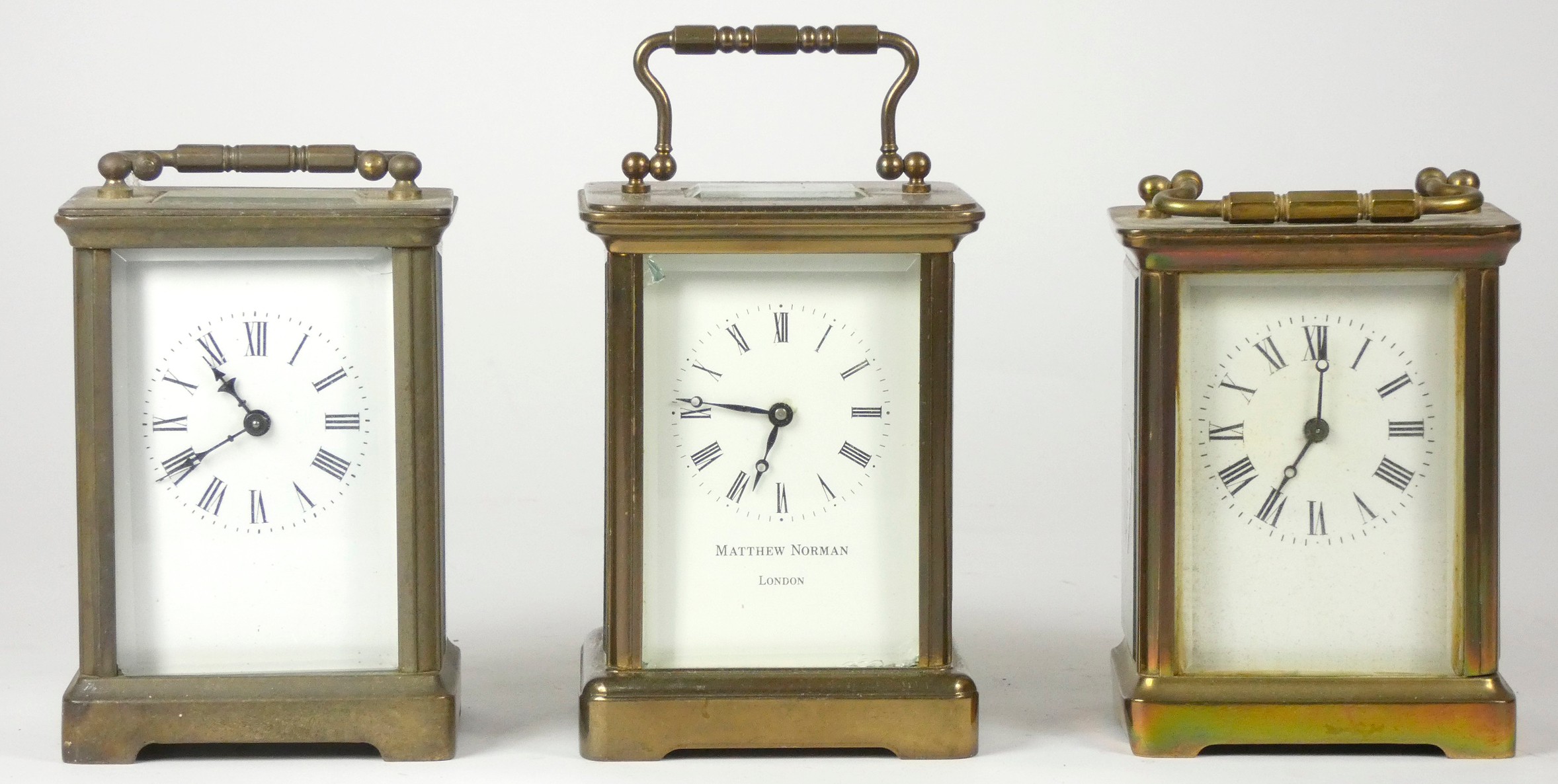 Three French mid 20th Century brass carriage clocks, white enameled dials with Roman numerals,
