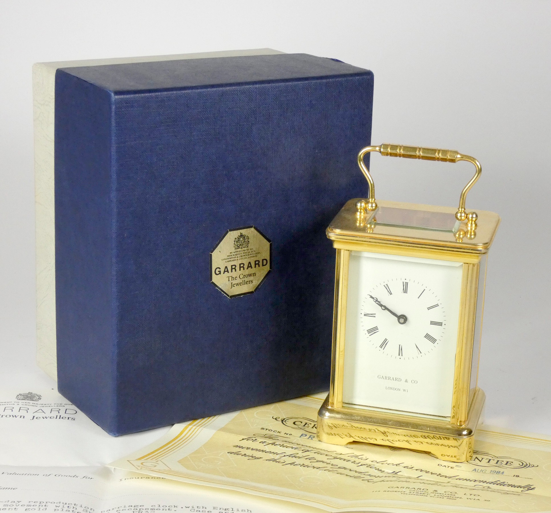 An English 8 day carriage clock, brass cased, bevel edged glass panels with enameled dial and