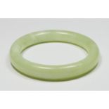 A jadeite bangle, untested for colour, internal diameter 64mm.