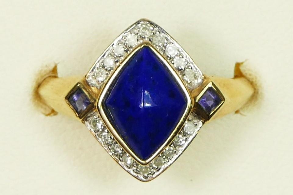 A 9ct gold, lapis lazuli and diamond dress ring, the lozenge collet set stone bordered by 18