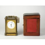 An early 20th Century carriage clock, brass cased, bevel edged glass panels with enameled dial,