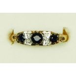 A 9ct gold sapphire three stone ring, diamond points between, carved claw setting, P 1/2, 1.6gm