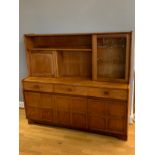 A mid 20th century teak display unit, open bookshelf over hinged door, opposite a glazed hinged