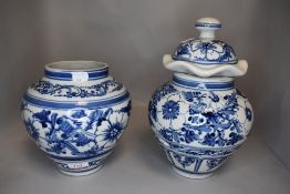 Two large ginger jars one having lid decorated in traditional delft designs