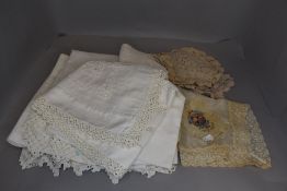 A selection of vintage and antique table linen including richly crotched table cloths, mats and